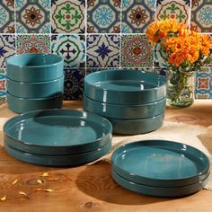 a table topped with plates and vases filled with flowers