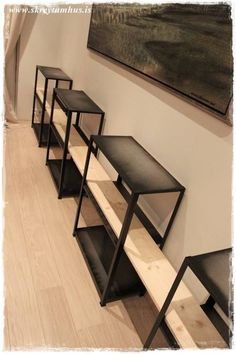 a row of black tables sitting on top of a hard wood floor