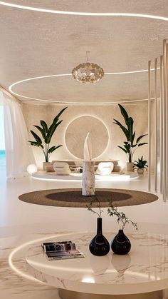 a living room filled with white furniture and lots of plants on top of the table