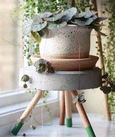 three planters stacked on top of each other in front of a window sill