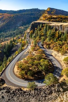 a winding road in the mountains surrounded by trees