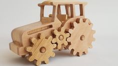 a wooden toy tractor with gears on the front and back wheels, made out of wood