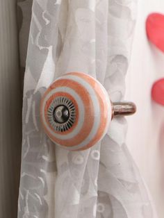 an orange and white knob on a curtain