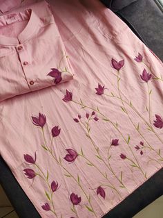 a pink shirt with purple flowers on it