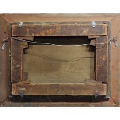 an old wooden frame with rope hanging from it's sides and the bottom part of the frame missing