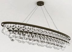 a chandelier hanging from the ceiling with wine glasses on it's sides