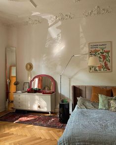 a bed room with a neatly made bed and a large mirror on the wall above it