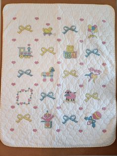 a white quilted blanket with various designs on it's sides and the words love written in small letters