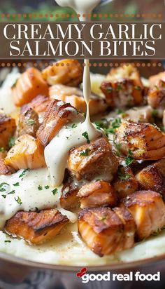 creamy garlic and salmon bites on top of mashed potatoes with sour cream drizzled over them