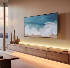 a large flat screen tv mounted to the side of a wall next to a wooden table