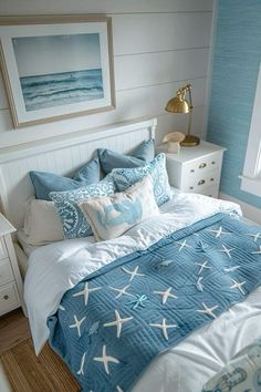 a bedroom with blue and white decor on the walls, along with an ocean themed bed