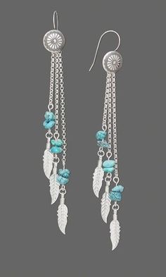 a pair of earrings with dangling beads and feathers on them, hanging from chain links