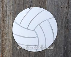 a white volleyball ornament hanging on a wooden wall