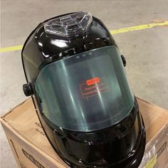 a black helmet sitting on top of a cardboard box