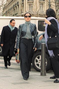 two women are walking down the street with one woman in black jacket and grey top