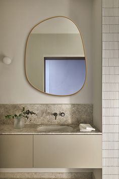 a bathroom with a sink, mirror and tiled flooring in the room that is well lit