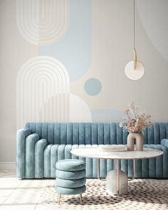 a blue couch sitting next to a table with a vase on top of it in front of a wall