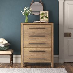 a wooden dresser sitting next to a blue wall