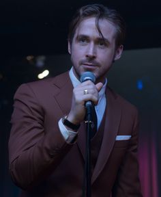 a man in a suit holding a microphone