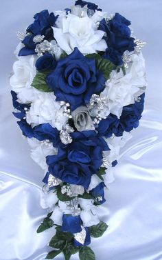 a bridal bouquet with blue and white flowers on a bed sheet in the shape of a heart