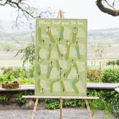 a golf course map on an easel with trees in the background