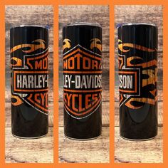 three black mugs with harley logos on them are sitting side by side in front of an orange background