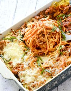 a casserole dish filled with spaghetti and meat