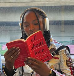 a woman reading a book while listening to headphones