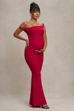 a woman in a red dress posing for the camera with her hands on her hips