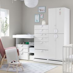 a baby's room with white furniture and accessories