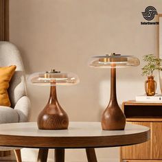 two wooden lamps sitting on top of a table next to a chair and lamp shade