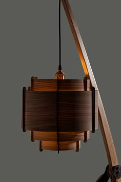 a wooden lamp hanging from the ceiling with a light bulb on it's side