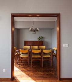 the dining room table is surrounded by yellow chairs