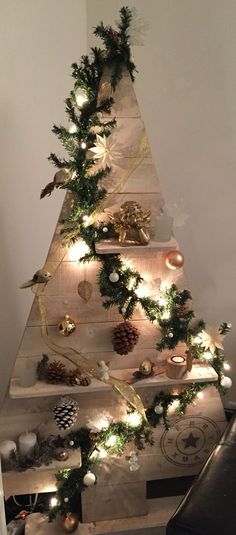 a christmas tree made out of wooden boards with lights on the top and decorations around it