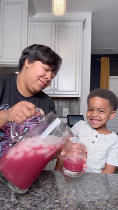 a man and boy are making smoothies in the kitchen