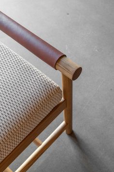 a close up of a wooden chair with fabric on it