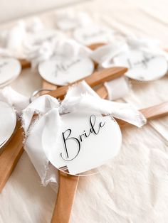 the bride and groom's name tags are on wooden clothes pins with ribbons tied around them