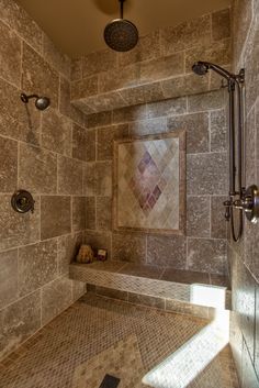 a walk in shower sitting next to a tiled wall and floor covered in brown tile