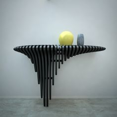 a black and yellow sculpture sitting on top of a wooden shelf next to a wall