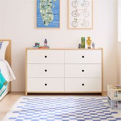 a white dresser sitting in a bedroom next to a blue and white checkered rug