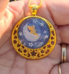 ONE of a KIND Necklace/Pendant. A Whimsical Scene created with stickers & topped with a glass cabochon on a Fancy STARS closed gold-tone bezel. It has a Gold-tone chain with a lobster clasp. This Fantasy Garden scene includes a Gold FAIRY sitting on a half-Moon surrounded by Silver STARS on a Blue background. KEY CHAIN / ZIPPER PULL option- Add $4.00 (you will get the exact item pictured in this listing).  You are responsible for converting your pendant to this accessory! PRICE with this option- Whimsical Stars, Unique Jewelry Necklace, Fairy Sitting, Fantasy Garden, Jewelry Tree, On The Moon, Silver Stars, Jewelry Necklace, Half Moon