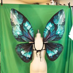 a white mannequin with blue butterfly wings on it