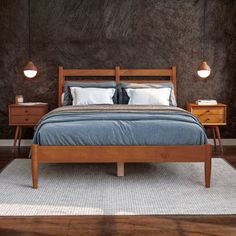 a bed sitting on top of a wooden floor next to two night stands with lamps