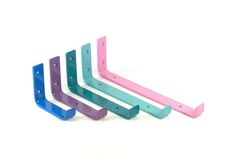 three different colored plastic brackets on a white background, one is blue and the other is pink