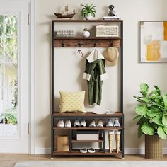 a coat rack with shoes and hats on it in front of a white door next to a potted plant