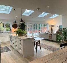 an open concept kitchen and living room with skylights