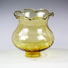 a yellow glass vase sitting on top of a table