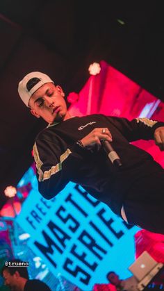 a man in black shirt and white hat performing on stage