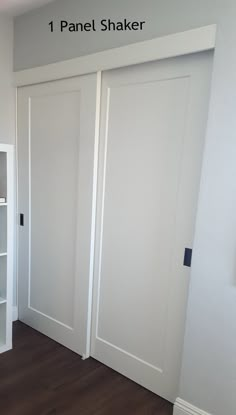 an empty room with white doors and shelving unit on the wall next to it