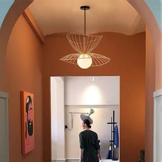 a woman standing in front of a mirror with an unusual hat on her head